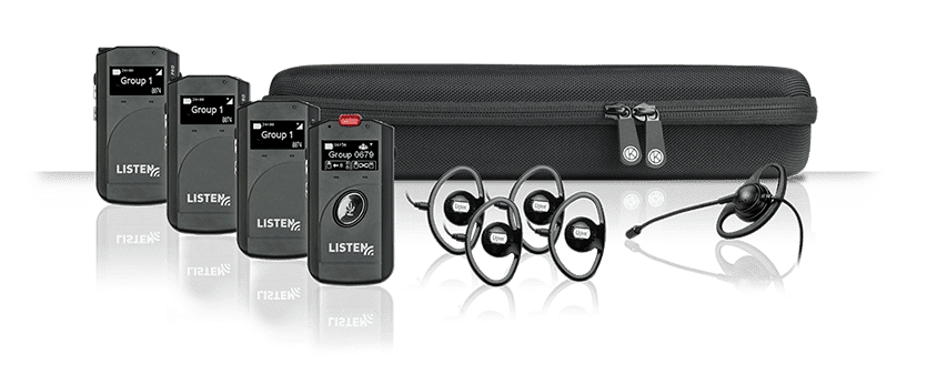 ListenTALK system composite with one transceiver, three receivers, four over the ear headsets, one microphone headset in front of a soft-side black, zipper-closed case.