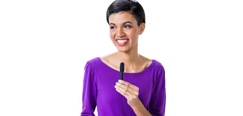 Woman holding the hand held microphone up to her mouth